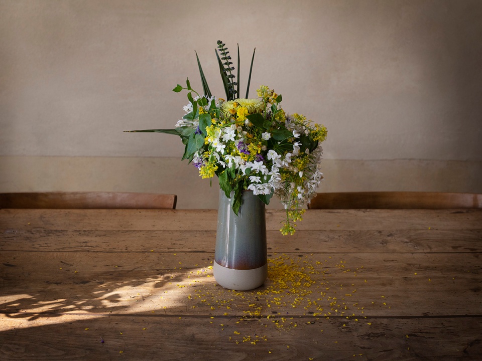 A bouquet of fading flower on an old wooden table. Un bouquet de fleur qui fane sur une vieille table en bois.
