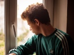 Portrait of a teenager during confinement in front of a window. Portrait d un adolescent pendant le confinement devant une fenetre.